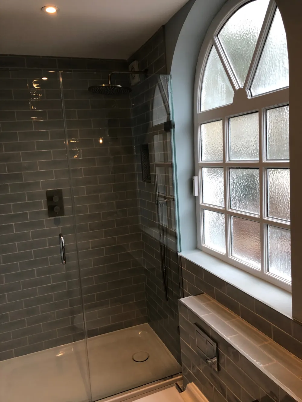 Completed walk-in shower enclosure with metro tiling and a thermostatic rainfall shower