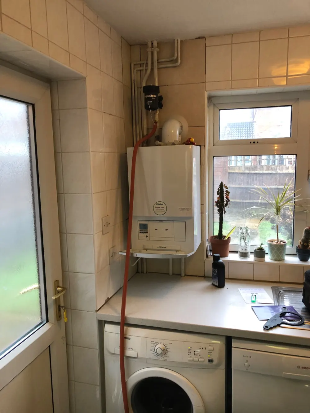 Central heating power flush in progress on a Vaillant boiler in a utility room