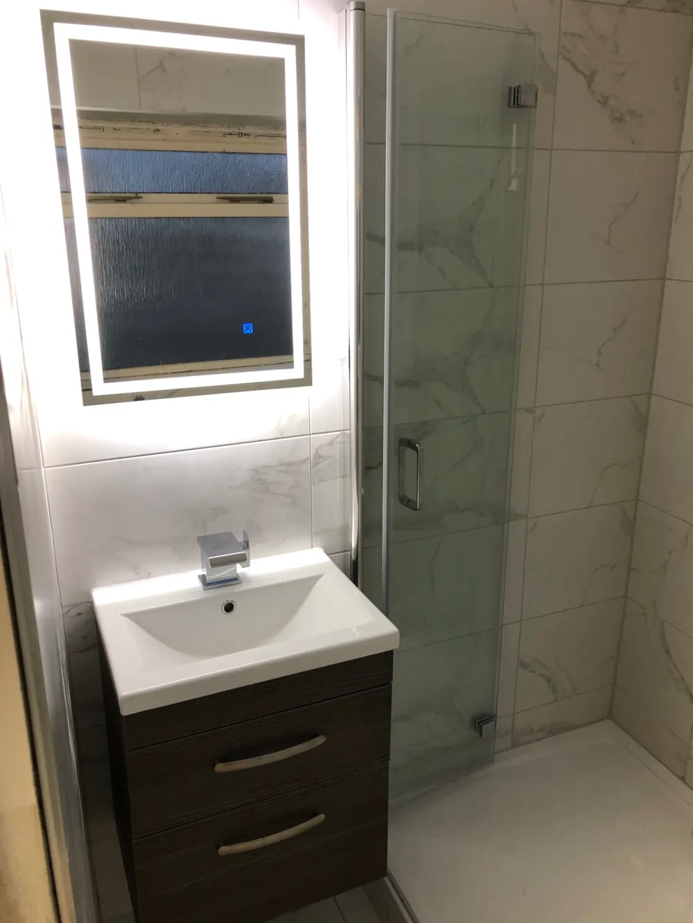 Fitted shower room with vanity unit, mixer tap and illuminated mirror