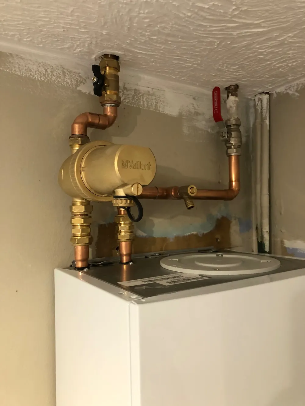 Vaillant heating pump and valves fitted above a wall-hung boiler
